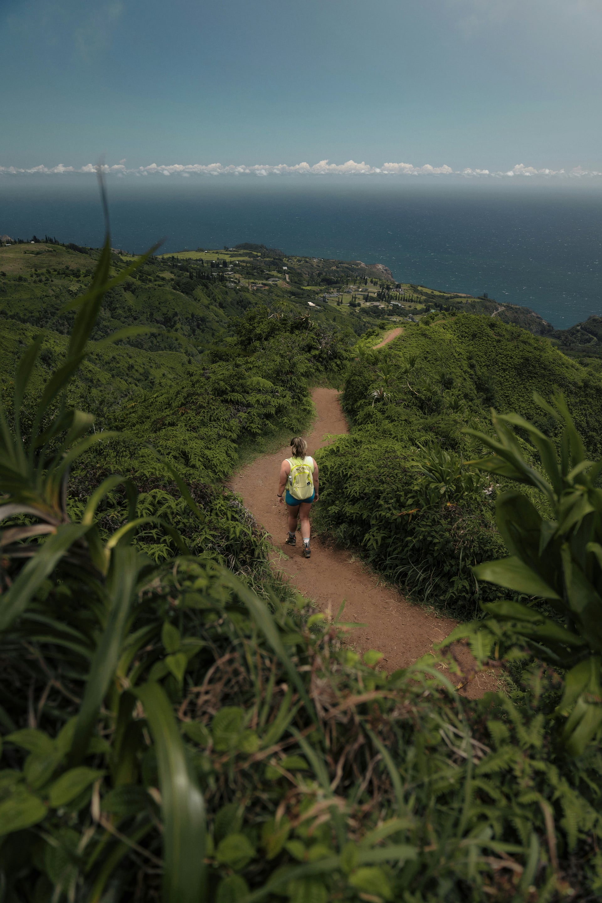 A hiker on Maui’s Waiheʻe Ridge Trail above the ocean